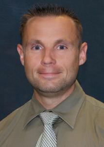 Headshot of Weston Kensinger with short brown hair in green shirt.