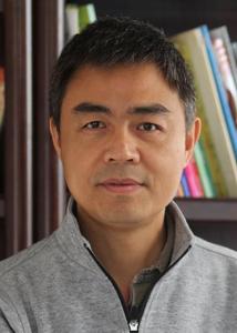 Headshot of Zhen Lei with short, cropped brown hair and gray zip-up sweater.